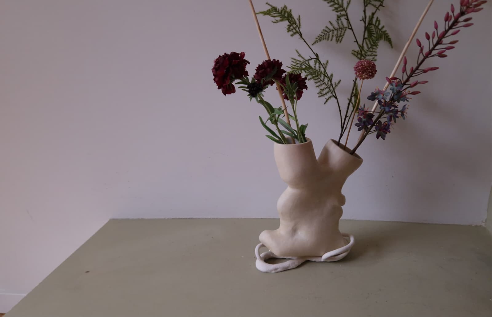 Handgevormde keramische vaas van Atelier Aardwerk met een bloemenboeket